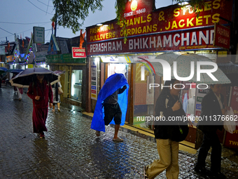 Pedestrians are carrying umbrellas during heavy rainfall in Darjeeling, India, on July 1, 2024. Darjeeling is a famous tourist destination i...