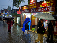 Pedestrians are carrying umbrellas during heavy rainfall in Darjeeling, India, on July 1, 2024. Darjeeling is a famous tourist destination i...