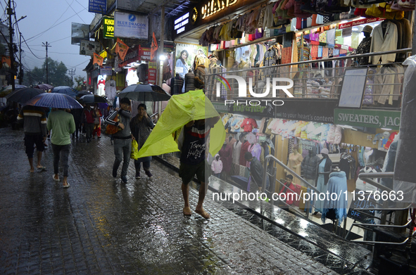 Pedestrians are carrying umbrellas during heavy rainfall in Darjeeling, India, on July 1, 2024. Darjeeling is a famous tourist destination i...