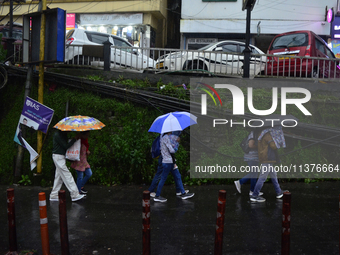 Pedestrians are carrying umbrellas during heavy rainfall in Darjeeling, India, on July 1, 2024. Darjeeling is a famous tourist destination i...