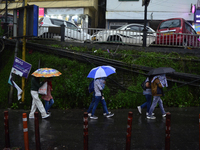 Pedestrians are carrying umbrellas during heavy rainfall in Darjeeling, India, on July 1, 2024. Darjeeling is a famous tourist destination i...