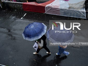 Pedestrians are carrying umbrellas during heavy rainfall in Darjeeling, India, on July 1, 2024. Darjeeling is a famous tourist destination i...