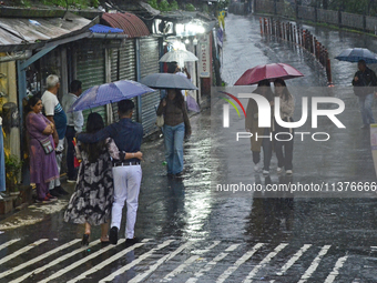 Pedestrians are carrying umbrellas during heavy rainfall in Darjeeling, India, on July 1, 2024. Darjeeling is a famous tourist destination i...