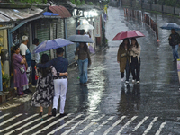 Pedestrians are carrying umbrellas during heavy rainfall in Darjeeling, India, on July 1, 2024. Darjeeling is a famous tourist destination i...