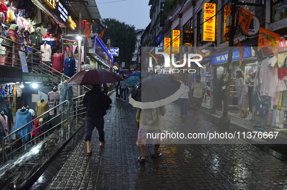 Pedestrians are carrying umbrellas during heavy rainfall in Darjeeling, India, on July 1, 2024. Darjeeling is a famous tourist destination i...