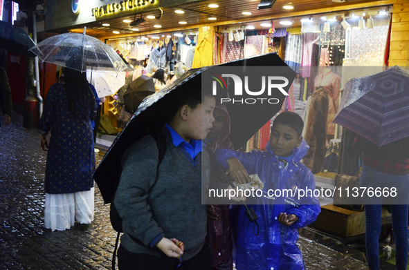 School children are carrying umbrellas during heavy rainfall in Darjeeling, India, on July 1, 2024. Darjeeling is a famous tourist destinati...