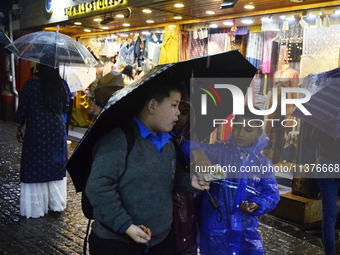 School children are carrying umbrellas during heavy rainfall in Darjeeling, India, on July 1, 2024. Darjeeling is a famous tourist destinati...