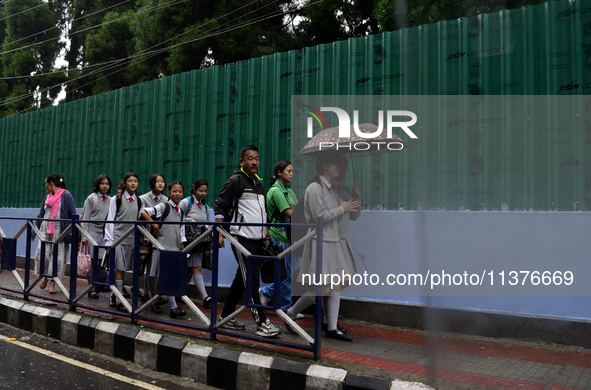 School students are carrying umbrellas during heavy rainfall in Darjeeling, India, on July 1, 2024. Darjeeling is a famous tourist destinati...