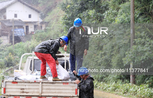 Power emergency repair workers are unloading emergency supplies in the rain at Si 'an village in Liuzhou city, Guangxi Province, China, on J...