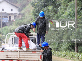 Power emergency repair workers are unloading emergency supplies in the rain at Si 'an village in Liuzhou city, Guangxi Province, China, on J...