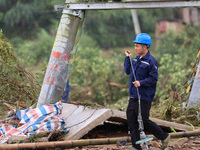 An electric worker is carrying out a repair operation at Si'an Village in Liuzhou, China, on July 2, 2024. (