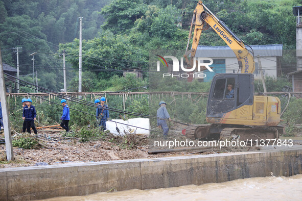 An electric worker is carrying out a repair operation at Si'an Village in Liuzhou, China, on July 2, 2024. 