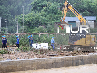 An electric worker is carrying out a repair operation at Si'an Village in Liuzhou, China, on July 2, 2024. (