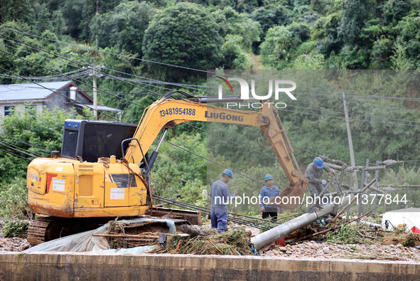 An electric worker is carrying out a repair operation at Si'an Village in Liuzhou, China, on July 2, 2024. 