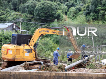 An electric worker is carrying out a repair operation at Si'an Village in Liuzhou, China, on July 2, 2024. (