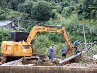 An electric worker is carrying out a repair operation at Si'an Village in Liuzhou, China, on July 2, 2024. (