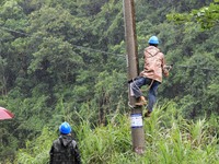 An electric worker is carrying out a repair operation at Si'an Village in Liuzhou, China, on July 2, 2024. (