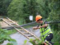 An electric worker is carrying out a repair operation at Si'an Village in Liuzhou, China, on July 2, 2024. (