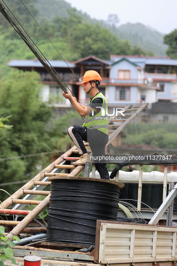 An electric worker is carrying out a repair operation at Si'an Village in Liuzhou, China, on July 2, 2024. 