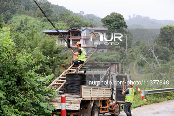 An electric worker is carrying out a repair operation at Si'an Village in Liuzhou, China, on July 2, 2024. 