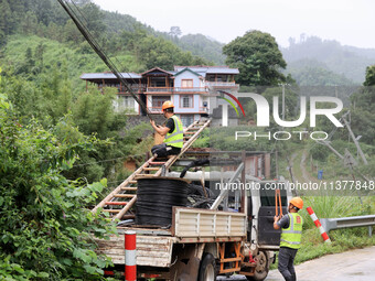 An electric worker is carrying out a repair operation at Si'an Village in Liuzhou, China, on July 2, 2024. (