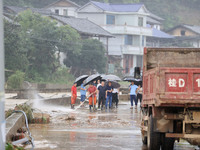 Workers are helping flood victims wash mud from a road at Si 'an village in Liuzhou, China, on July 2, 2024. (