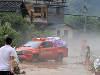 A worker is driving a vehicle to transport emergency supplies at Si 'an Village in Liuzhou, China, on July 2, 2024. (