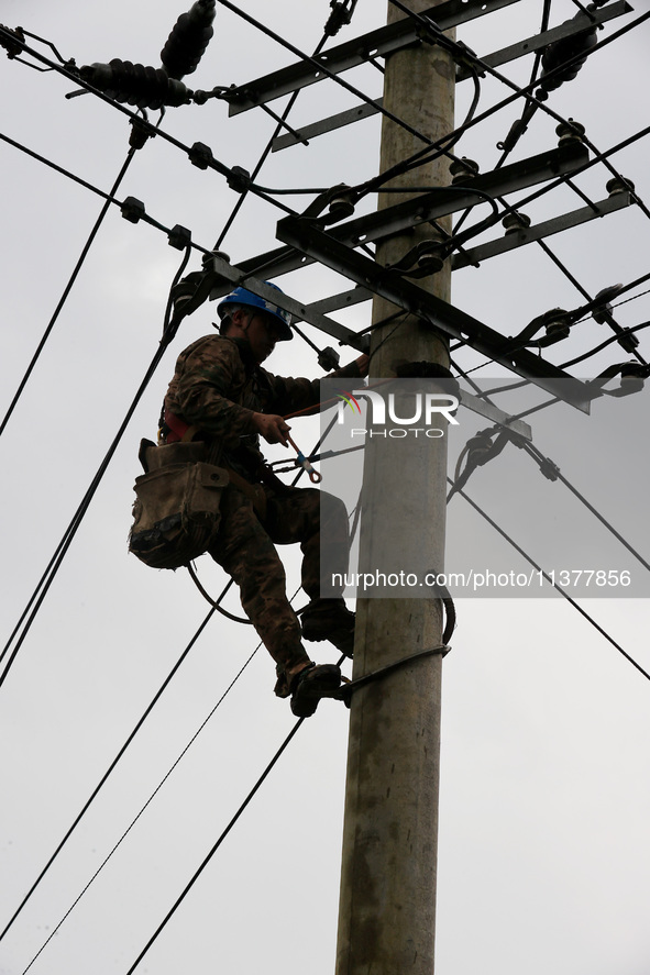 A power repair worker is working on a pole in Si 'an village, Liuzhou city, Guangxi province, China, on July 2, 2024. 