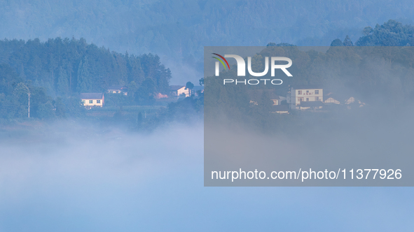 The fields, houses, mountains, and villages of Zhimu Village are appearing in the morning fog after returning farmland to forest in Chongqin...