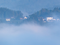 The fields, houses, mountains, and villages of Zhimu Village are appearing in the morning fog after returning farmland to forest in Chongqin...