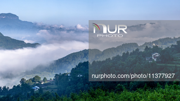 The fields, houses, mountains, and villages of Zhimu Village are appearing in the morning fog after returning farmland to forest in Chongqin...