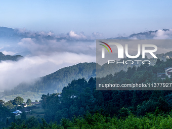 The fields, houses, mountains, and villages of Zhimu Village are appearing in the morning fog after returning farmland to forest in Chongqin...