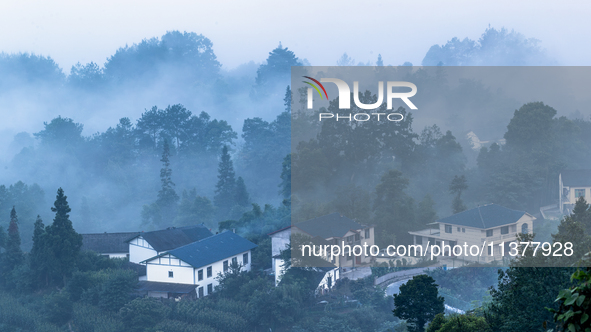 The fields, houses, mountains, and villages of Zhimu Village are appearing in the morning fog after returning farmland to forest in Chongqin...