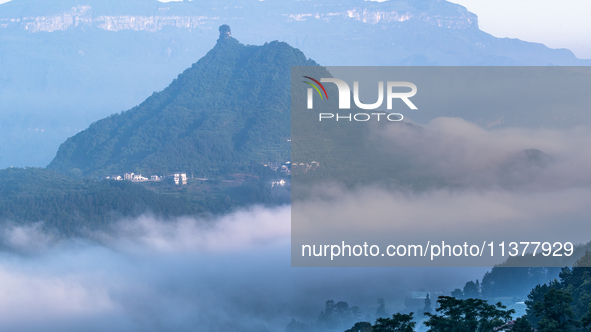 The fields, houses, mountains, and villages of Zhimu Village are appearing in the morning fog after returning farmland to forest in Chongqin...