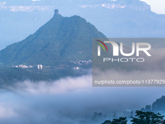 The fields, houses, mountains, and villages of Zhimu Village are appearing in the morning fog after returning farmland to forest in Chongqin...