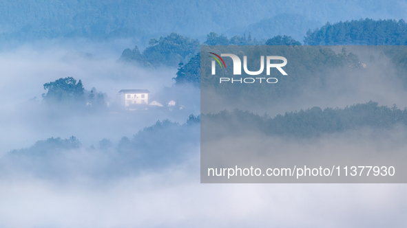 The fields, houses, mountains, and villages of Zhimu Village are appearing in the morning fog after returning farmland to forest in Chongqin...