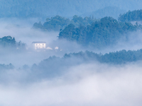 The fields, houses, mountains, and villages of Zhimu Village are appearing in the morning fog after returning farmland to forest in Chongqin...