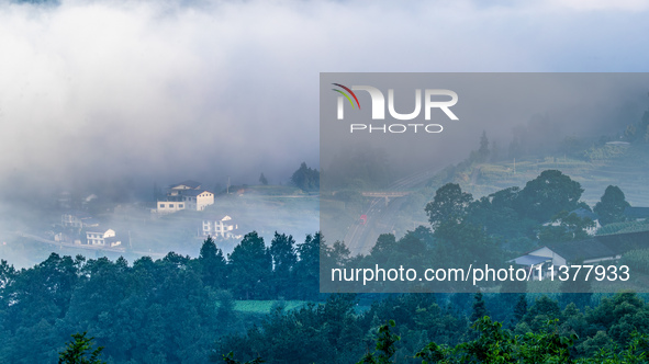 The fields, houses, mountains, and villages of Zhimu Village are appearing in the morning fog after returning farmland to forest in Chongqin...