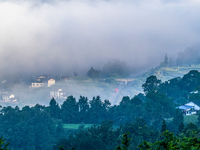 The fields, houses, mountains, and villages of Zhimu Village are appearing in the morning fog after returning farmland to forest in Chongqin...