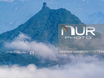 The fields, houses, mountains, and villages of Zhimu Village are appearing in the morning fog after returning farmland to forest in Chongqin...