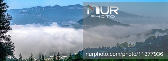 The fields, houses, mountains, and villages of Zhimu Village are appearing in the morning fog after returning farmland to forest in Chongqin...