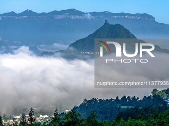 The fields, houses, mountains, and villages of Zhimu Village are appearing in the morning fog after returning farmland to forest in Chongqin...