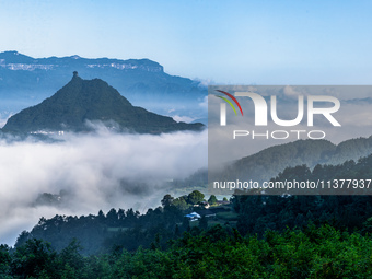 The fields, houses, mountains, and villages of Zhimu Village are appearing in the morning fog after returning farmland to forest in Chongqin...