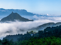 The fields, houses, mountains, and villages of Zhimu Village are appearing in the morning fog after returning farmland to forest in Chongqin...