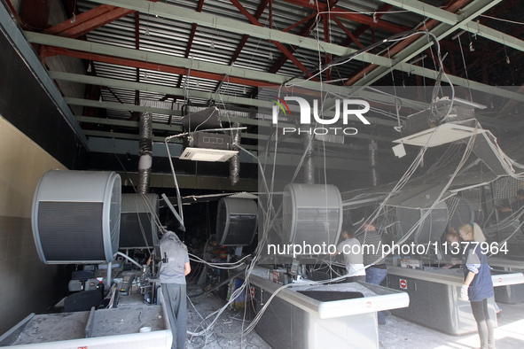 People are removing the debris from a supermarket damaged by a recent Russian missile attack in Dnipro, Ukraine, on July 1, 2024. Russia is...