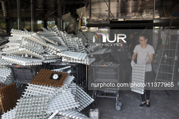 People are removing the debris from a supermarket damaged by a recent Russian missile attack in Dnipro, Ukraine, on July 1, 2024. Russia is...