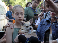 A girl affected by a recent Russian missile attack is holding a dog as she faces the press in Dnipro, Ukraine, on July 1, 2024. Russia is la...