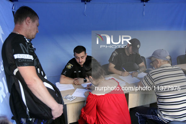 Police officers are helping locals affected by a recent Russian missile attack at a coordination headquarters in Dnipro, Ukraine, on July 1,...