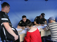 Police officers are helping locals affected by a recent Russian missile attack at a coordination headquarters in Dnipro, Ukraine, on July 1,...