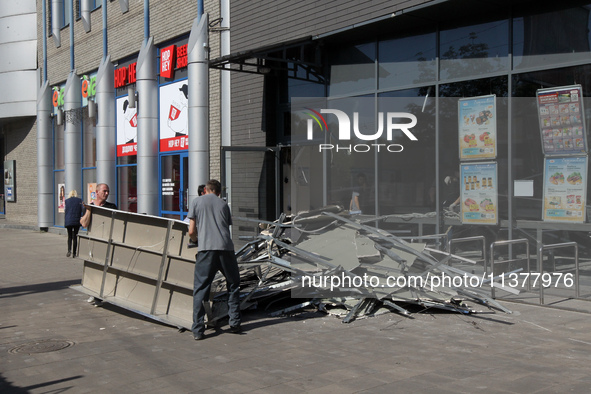 Men are carrying damaged items out of a supermarket affected by a recent Russian missile attack in Dnipro, Ukraine, on July 1, 2024. Russia...